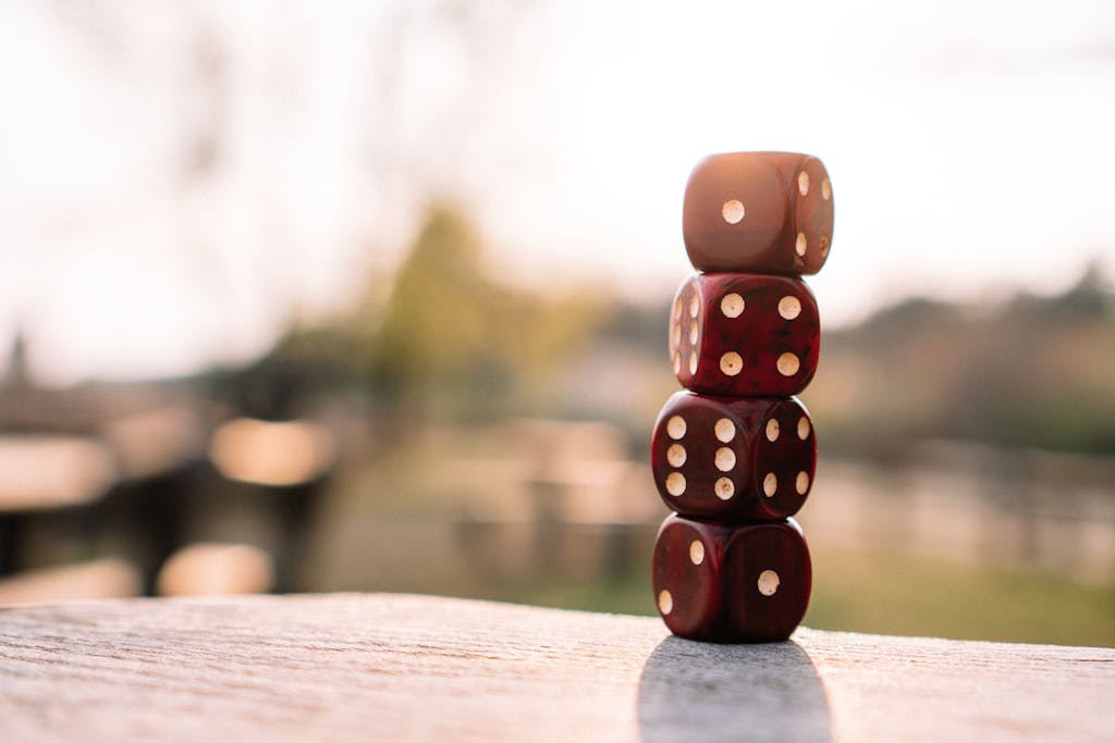 BLOG VIEW Naijastudyhub Set of red dice stacked together on wooden table placed on sunny terrace in daylight